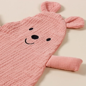 Close-up of pink muslin cotton baby security blanket with embroidered bear ears and face