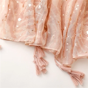 Close-up of pink linen-touch scarf featuring rose gold foil dots and fringe tassels