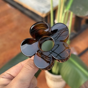 Vue détaillée d'une pince à cheveux fleur ambre de 8 cm avec texture écaille de tortue