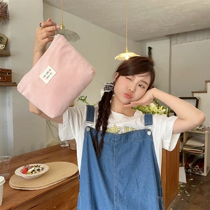 Detail view of pink corduroy makeup bag with zakka label shown in a lifestyle setting