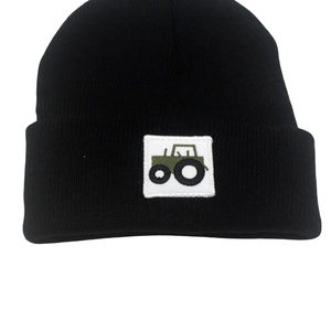 Detail view of the green tractor patch embroidered on black knitted beanie for children