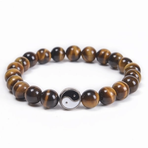Detail of beaded tiger eye bracelet with black and white yin yang tai chi charm