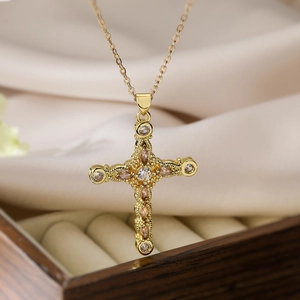Macro detail of gold-plated cross pendant with champagne marquise-cut zircon on satin
