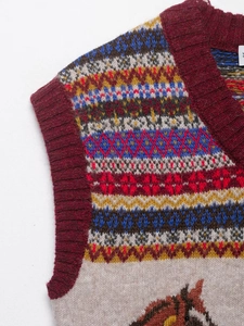 Detail of Fair Isle knit vest with colorful pattern and horse motif embroidery
