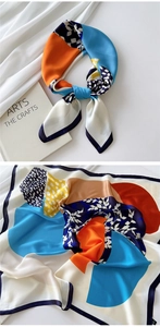 Detail of multi-color silk scarf with geometric floral patterns and fine stitching
