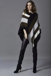 Detail of color-block striped knit poncho with fringe hem on a professional fashion model