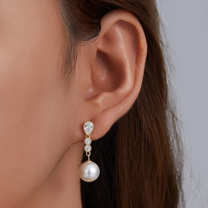 Elegant sterling silver pearl drop earrings with sparkling cubic zirconia on model