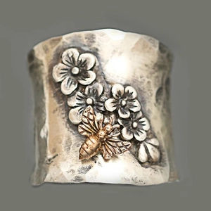 Hammered silver wide band ring featuring silver flowers and a golden honey bee accent