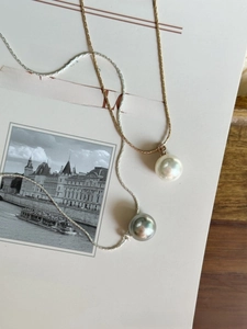 Detailed macro view of white and grey pearls with metallic luster on snake bone chains