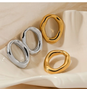 Artistic set of wavy irregular gold and silver rings displayed in a shell tray