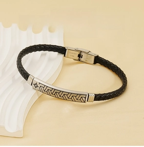 Nahaufnahme von schwarzem geflochtenem Lederarmband mit graviertem Edelstahl-Magnetverschluss