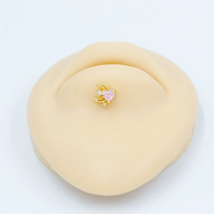 Vue détaillée d'un clou de lune doré avec zircon cœur rose sur le cartilage de l'oreille