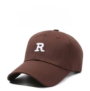 Detailed view of white R letter embroidery on a brown cotton canvas baseball cap