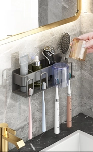 Detail view of wall-mounted gun grey bathroom rack holding electric toothbrushes and cups