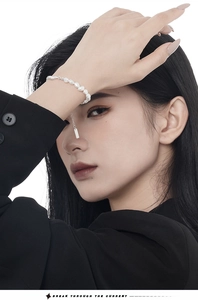 Close-up of S925 sterling silver bracelet featuring irregular pearls and a square pendant