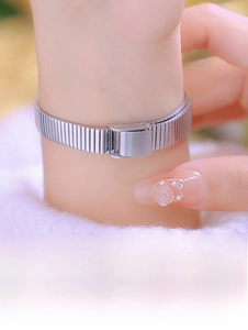 Macro detail of silver stainless steel Milanese mesh watch strap on a woman wrist