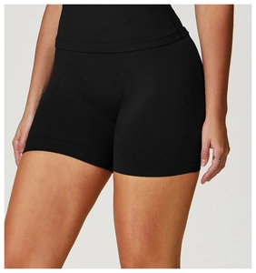 Detail of high-waisted seamless yoga shorts in black stretch fabric with wide leg hem