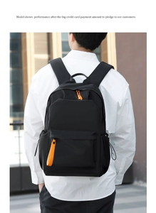 Detailed view of black waterproof oxford backpack with orange zippers on a model's back