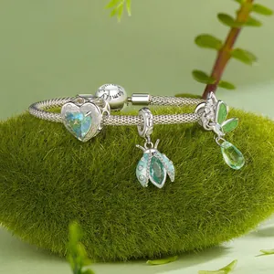 925 silver insect charm bracelet with teal heart and blue beetle on green moss