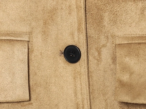Close-up of brown faux suede blazer with classic black buttons and pocket flap details