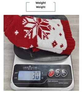 Close-up of a 30g red and white knitted wine bottle cover showing weight on a digital scale