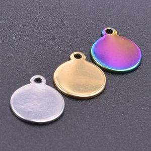 Macro shot of 18k gold, silver, and rainbow stainless steel round disc charm pendants