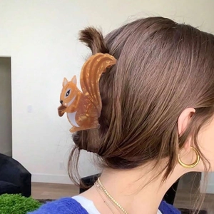 Cute squirrel claw clip in amber orange acetate displayed on a woman's hair