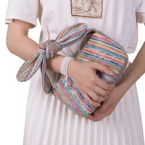 Detail einer farbenfroh gewebten Stroh-Clutch mit dekorativem Schultergurt mit Schleife