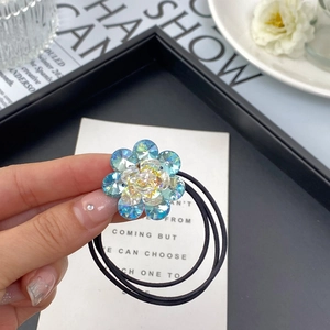 Close-up of double-layer crystal flower hair tie with blue and iridescent rhinestones