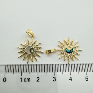 Macro detail of sun and moon pendants with shell inlays and scale for size reference