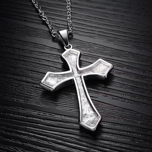 Vintage silver titanium steel cross pendant necklace with textured detail on wood surface