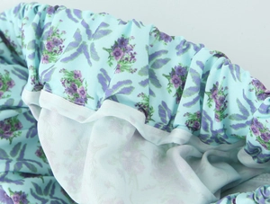 Detailed view of elastic waistband stitching on light blue floral polyester fabric