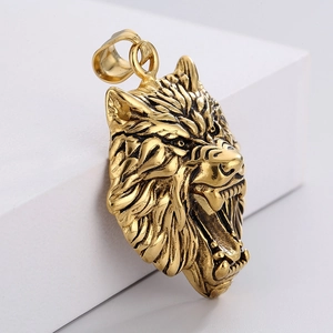 Macro detail of antique gold wolf head pendant with textured finish on a pedestal