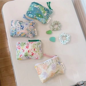 Flat lay of small floral cotton zipper pouches with simple wish label and colorful puller