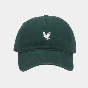 Close-up of dark green cotton baseball cap with white eagle embroidery and textured fabric
