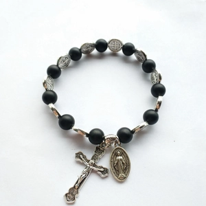Detailed macro shot of the silver crucifix and Miraculous Medal on black prayer beads