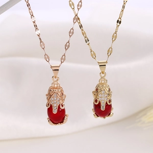 Macro detail of red stone Pi Xiu pendants in gold and rose gold titanium steel plating