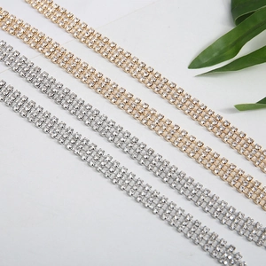 Nahaufnahme der glitzernden dreireihigen Strassketten in Gold und Silber für Details.
