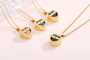 Detailed shot of golden MOM heart necklaces featuring vibrant birthstone gemstones