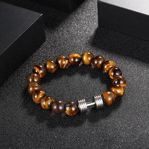 Vue détaillée des perles œil de tigre et du charme haltère en acier sur un bracelet