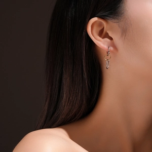 Detail shot of a mixed-metal chain earring with gold and silver links on a model