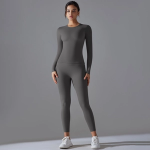 Vue de face de l'ensemble de yoga gris foncé avec legging taille haute et haut à manches longues