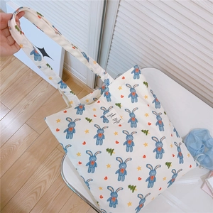 Close-up of cute rabbit print on white cotton tote bag with stars and heart details