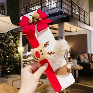Christmas hair accessory set with elk headband and bow hairpins held in a cafe setting