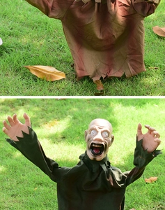 Detail of life-size zombie prop with tattered clothes and glowing eyes for Halloween decor