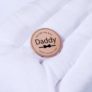 Close-up of rose gold Daddy pendant with Father's Day engraving being held in hand