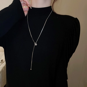 Silver adjustable Y-shaped long necklace on black turtleneck sweater for autumn and winter