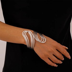 Detail showing the layered silver wavy cuff bracelet with a textured brushed metal finish