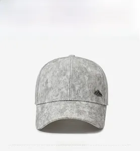 Detail view of the gray textured baseball cap with a metal mountain logo on the side