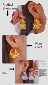 Detailed view of large gold and silver C-shaped twisted earrings with shell texture